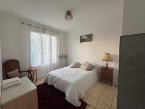 a bedroom with a bed and a chair and a window at Le GIGI in Antony
