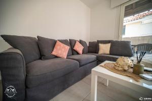 a gray couch in a living room with a table at Les Embruns - Mer - Terrasse in Le Grau-du-Roi