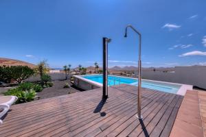 a wooden deck with a swimming pool on a house at Villa El Erizo - Pool By Lanzarote Vacation Homes in Nazaret +104 photos
