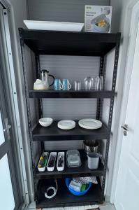 a black shelf with plates and dishes on it at Strandkiewiet in Jacobs Bay