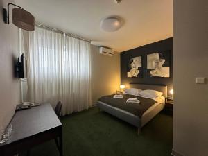 a hotel room with a bed and a desk at Centrum Konferencyjno-Apartamentowe Mrówka in Warsaw