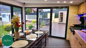 a room with tables and chairs and a large window at Sinaia ZenDen - Private Villa & SPA in Sinaia