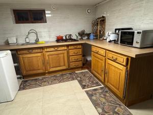 a kitchen with wooden cabinets and a microwave at Le GIGI in Antony