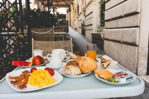 a table with plates of breakfast foods on it at Hotel Fellini a Fontana di Trevi in Rome +119 photos