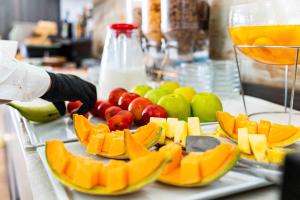 a tray of fruit on a counter with a person wearing gloves at Hotel Fellini a Fontana di Trevi in Rome