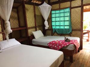 a room with two beds and a window at Hutyee Boat Bungalow in Ko Lanta