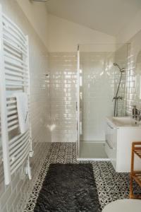 a white bathroom with a shower and a sink at Faház- Naplemente in Véménd