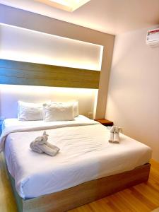 a bedroom with a bed with white sheets and shoes on it at Coconut Condo Aonang in Ao Nang Beach