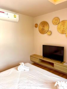 a bedroom with a tv and a bed and a tvicterictericter at Coconut Condo Aonang in Ao Nang Beach