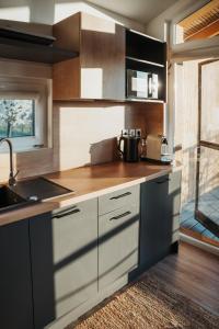 a kitchen with white cabinets and a sink and a counter at Faház- Naplemente in Véménd