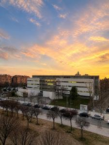 a building with a parking lot in front of a sunset at Residencial Lleida in Lleida