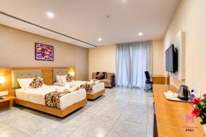 a hotel room with two beds and a couch at Millennials Hotel in Kammasandra