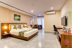 a hotel room with a bed and a television at Millennials Hotel in Kammasandra