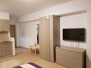 a living room with a flat screen tv on a wall at De Silva Residence in Mamaia