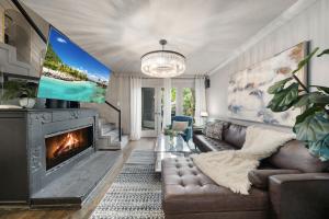a living room with a couch and a fireplace at Spacious Loft Condo w Pool & Fireplace in Dallas