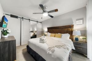 a bedroom with a large bed and a ceiling fan at Spacious Loft Condo w Pool & Fireplace in Dallas +35 photos