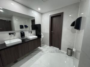 a bathroom with two sinks and a mirror at Vaishnavi Beacon Hotel Patna in Patna