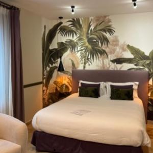 a bedroom with a white bed with a painting on the wall at Villa Pruly Hotel Cannes Centre in Cannes