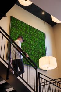 a man walking down a staircase in front of a green wall at Easy Stay Næstved in Næstved