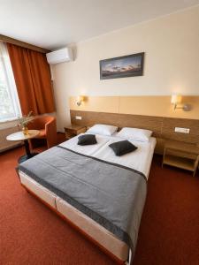 a hotel room with a large bed and a chair at Info Hotel in Palanga
