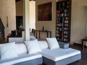 a living room with a couch and a book shelf at Villa Bossi Bali at Tanguwesia in Bubunan
