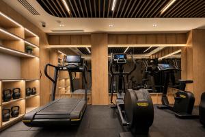 a gym with several treadmills and machines in a room at Hotel Maison Orient in Bucharest