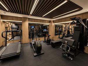 a gym with several treadmills and machines in a room at Hotel Maison Orient in Bucharest