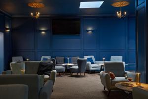 a waiting room with blue walls and chairs and tables at Luccombe Hall Hotel in Shanklin