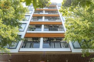 an apartment building with balconies and trees at Seasol Beach Boutique hotel in Danang