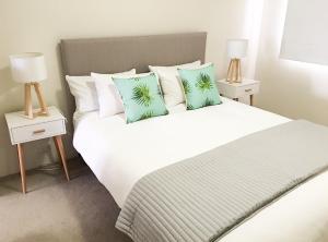 a bedroom with a large white bed with pillows at Seaspray Villa 5 in Shoal Bay