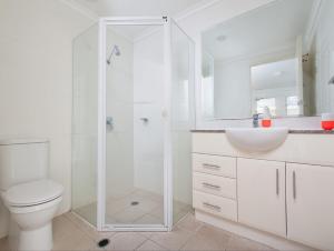a bathroom with a shower and a toilet and a sink at Seaspray Villa 5 in Shoal Bay