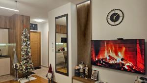 a living room with a fireplace and a christmas tree at Zlatibor Centar Lux in Zlatibor