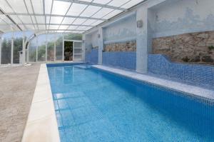 a large swimming pool with blue tiles in a building at El Balcón de La Safor - Llumicel in Ador