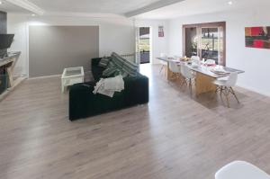 a living room with a black couch and a table at El Balcón de La Safor - Llumicel in Ador