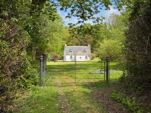 a gate in front of a house in a field at Foresters Cottage, Dalry in Dalry