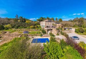 an old stone house with a swimming pool on a hill at Mas du pommier Gala in Gagnières