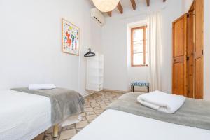 a bedroom with two beds and a window at Can Romaguera in Algaida +25 photos