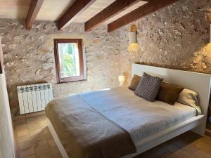 a bedroom with a large bed in a stone wall at Can Pina - Eco Pina - in Costitx