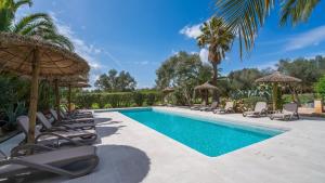 a swimming pool with lounge chairs and umbrellas at Can Pina - Eco Pina - in Costitx