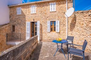 a patio with a table and chairs in front of a building at Can Romaguera in Algaida
