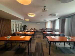 a dining room with wooden tables and chairs at Centrum Konferencyjno-Apartamentowe Mrówka in Warsaw