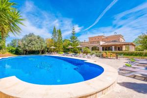 a pool with chairs and a house in the background at Na Pont in Campos