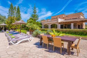 a patio with a table and chairs and a building at Na Pont in Campos