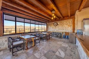 a dining room with tables and chairs and windows at The Calypso Cave in Ürgüp