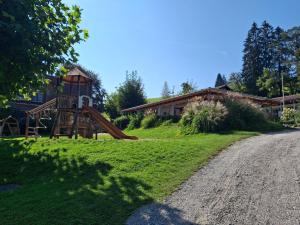 a playground in front of a house and a road at Luxus Wohnwagen Alpenblick in Weiler-Simmerberg