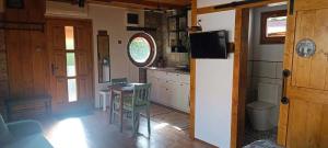 a kitchen with a table and a kitchen with a door at Kajüt Apartman in Balatonfenyves