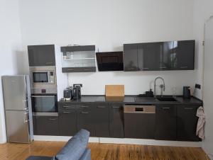 a kitchen with black cabinets and stainless steel appliances at Ferienwohnung Altstadt Lemgo in Lemgo