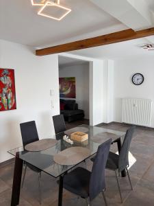 a dining room with a glass table and chairs at Ferienwohnung RaHo in Wadgassen