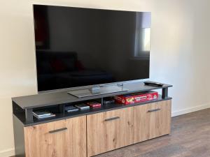a large flat screen tv on a wooden entertainment center at Ferienwohnung RaHo in Wadgassen