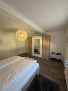 a bedroom with a large bed and a chandelier at Ferienwohnung RaHo in Wadgassen